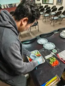 Co Founder of M&M Wealth Associates, Matthew Wu preparing food for community event.